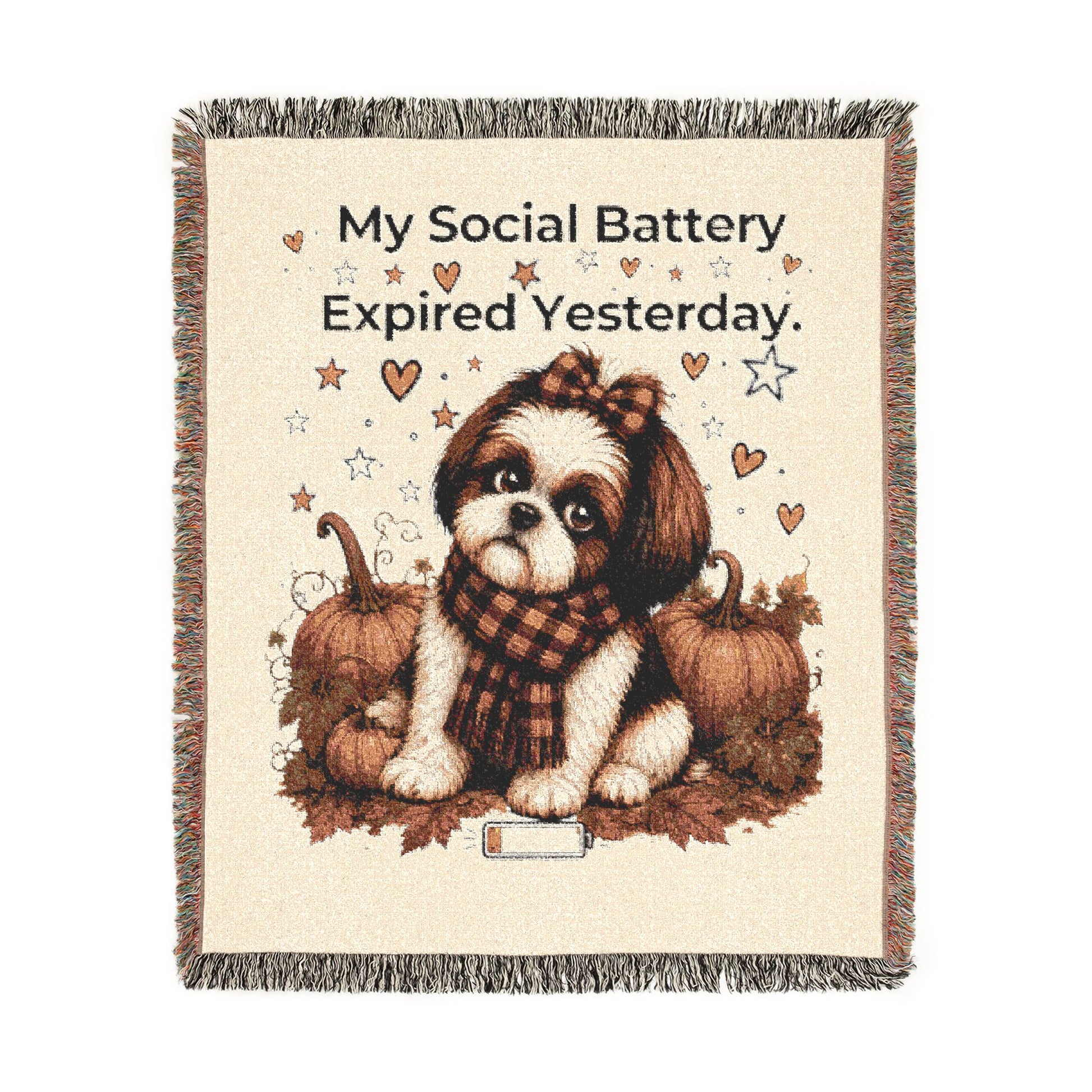 A square woven throw blanket with fringe edges, featuring a cream background and a central illustration of a small brown-and-white dog sitting between pumpkins and autumn leaves. Above the dog, the text reads, 'My Social Battery Expired Yesterday.