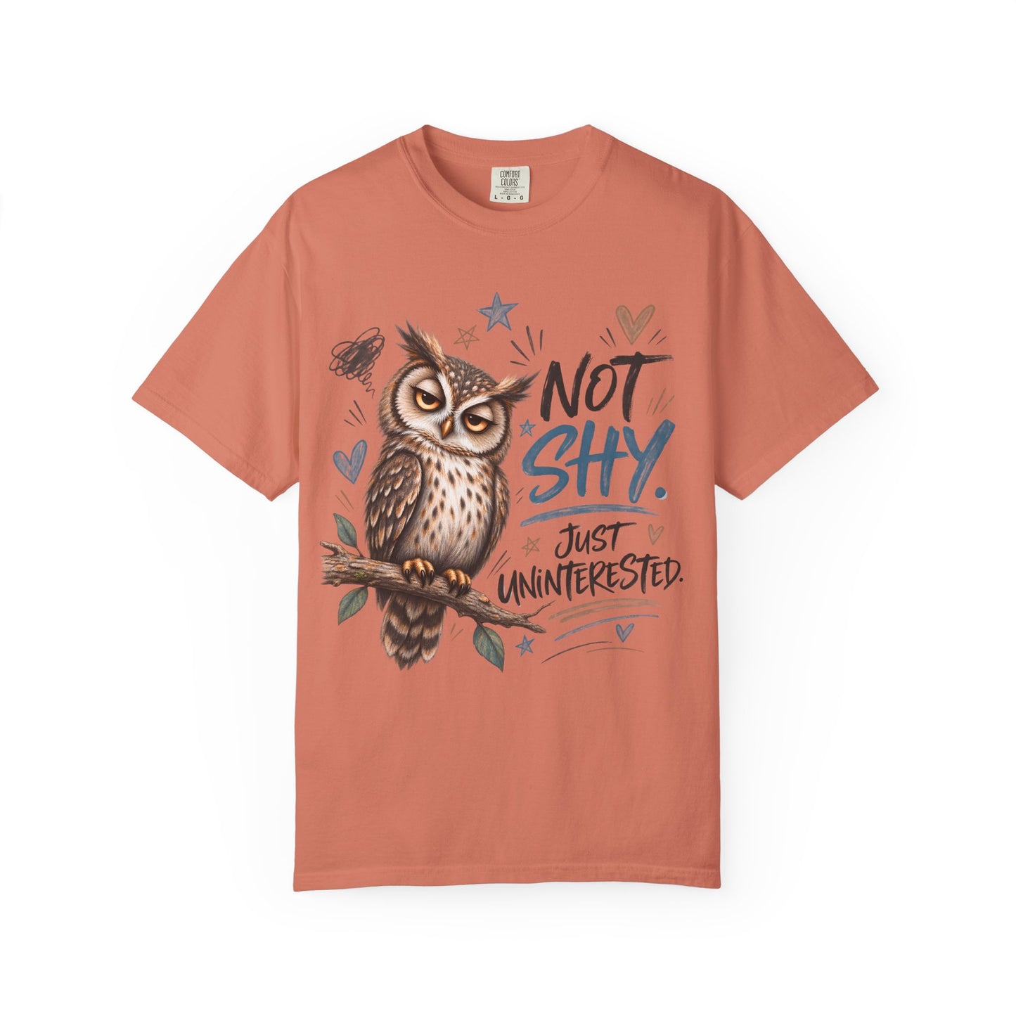 A coral orange crewneck t-shirt featuring a graphic of an owl perched on a branch with the text 'NOT SHY. JUST UNINTERESTED.