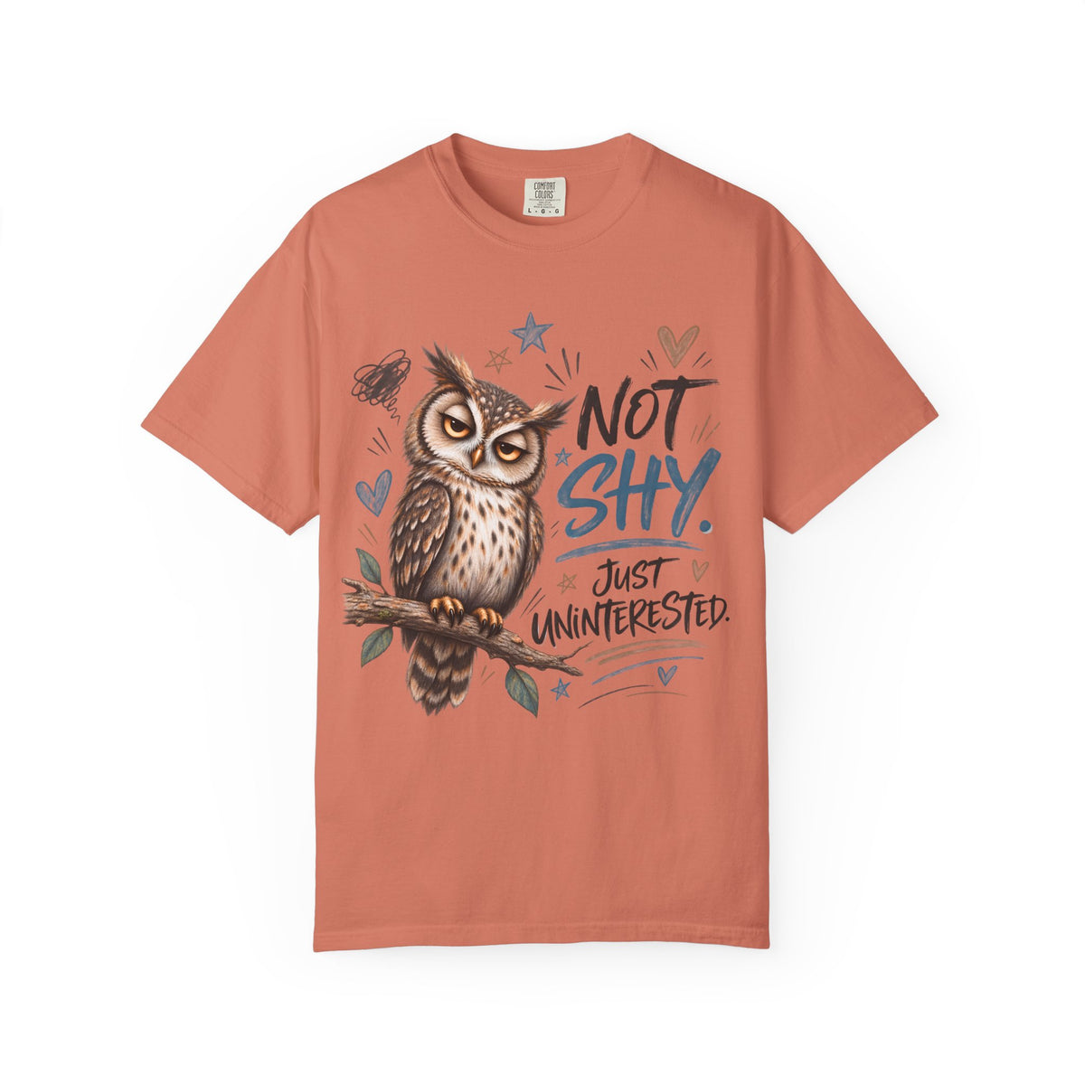 A coral orange crewneck t-shirt featuring a graphic of an owl perched on a branch with the text 'NOT SHY. JUST UNINTERESTED.