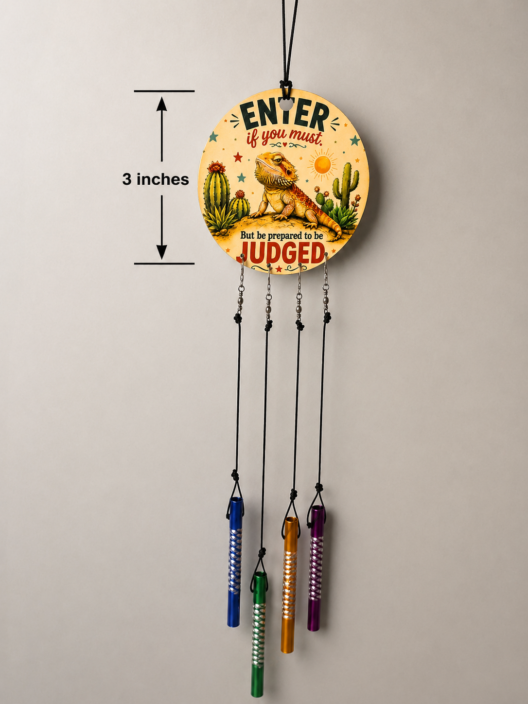 Decorative wall hanging with cactus design and text on a plain background