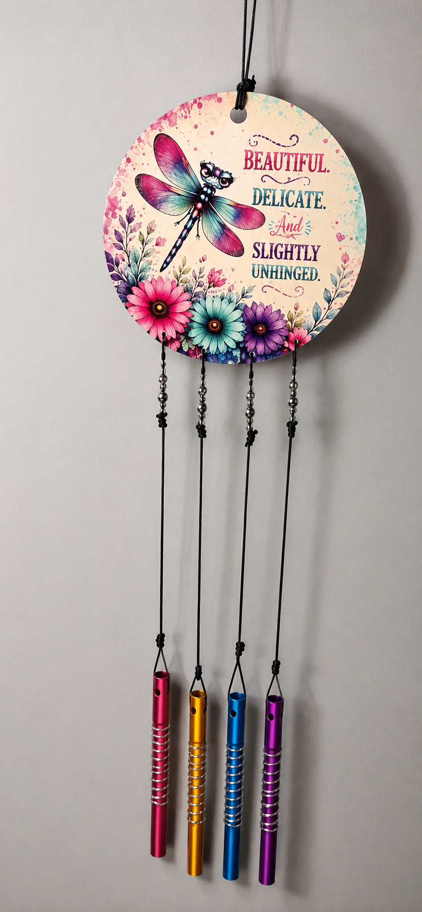 Decorative wall hanging with floral design and colorful tassels on a gray background