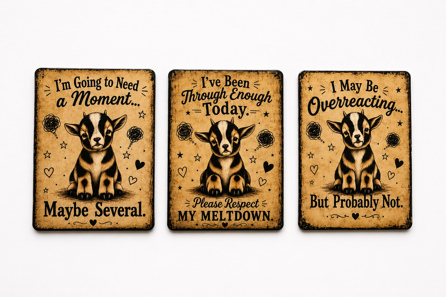 Three rectangular decorative signs with rounded corners displayed side by side on a light gray background. Each sign features a distressed tan background with black text and an illustration of a goat.