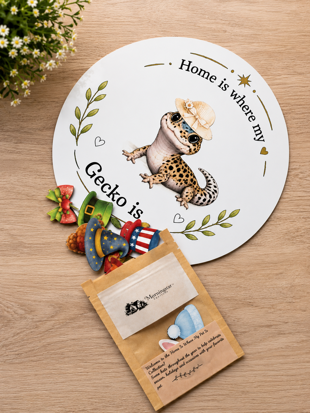 Decorative sign with a gecko illustration and decorative items on a wooden surface