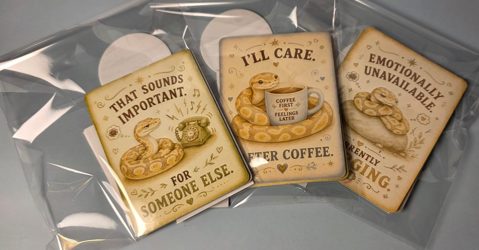 Three decorative snake-themed magnets with snake illustrations and humorous text on a clear background
