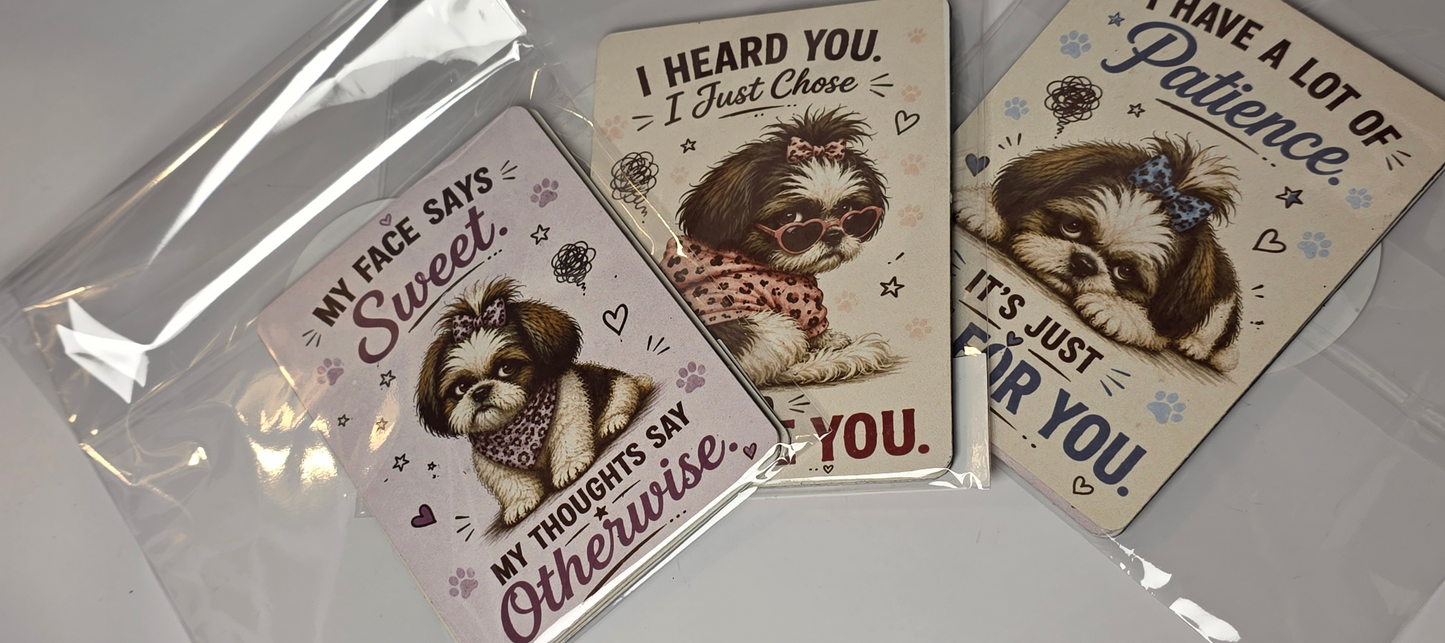 Three dog-themed magnets with humorous sayings on a reflective surface.