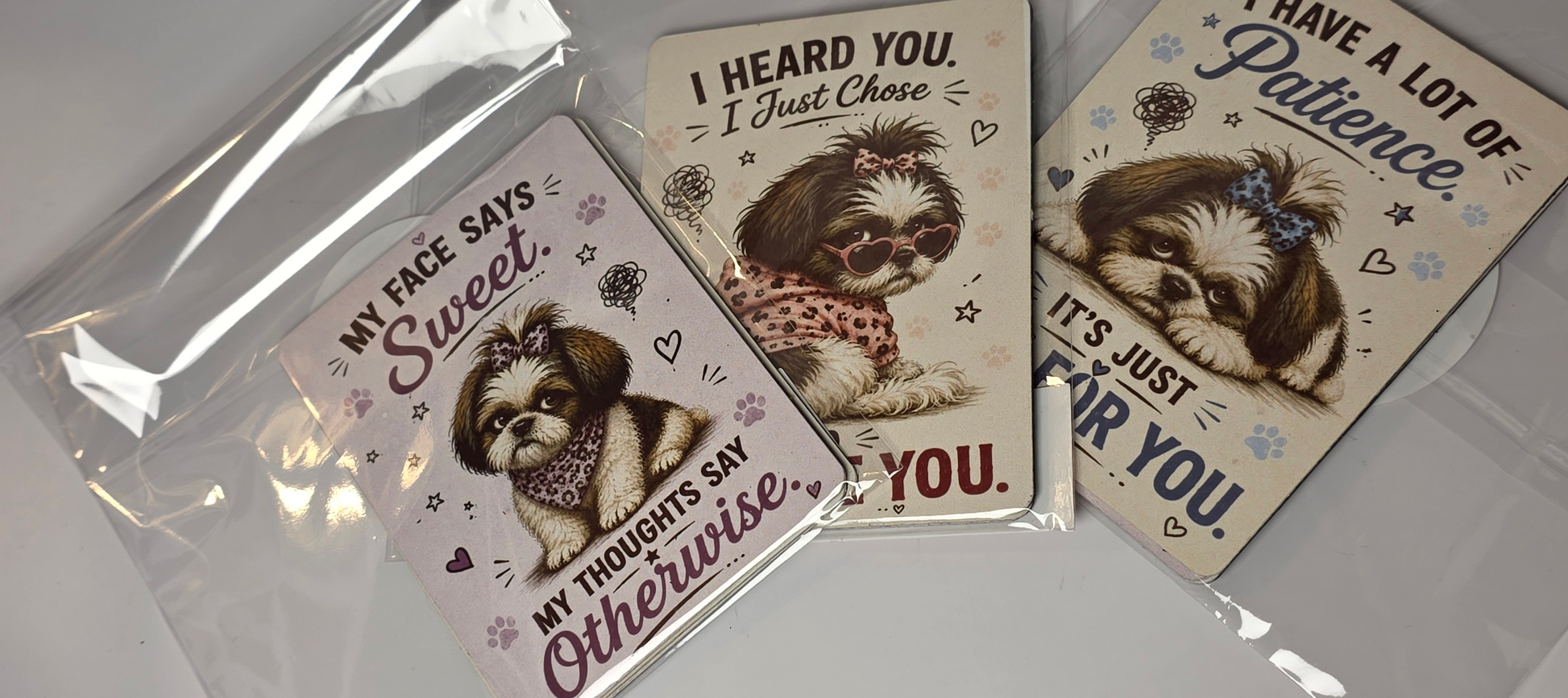 Three dog-themed magnets with humorous sayings on a reflective surface.