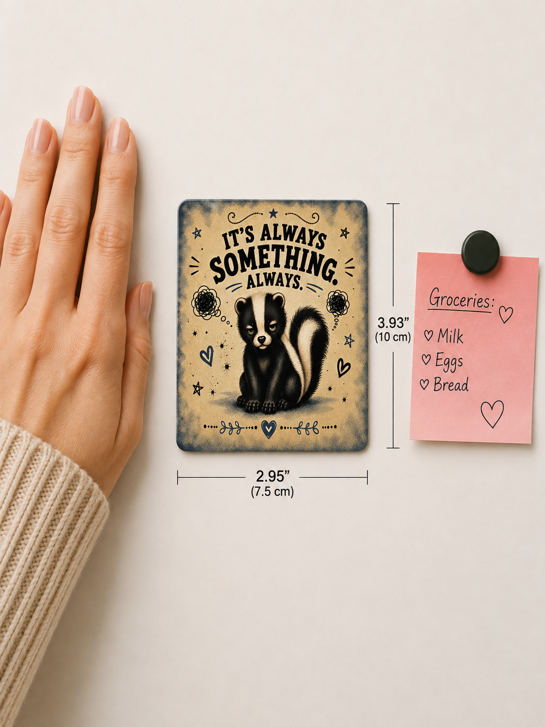 A rectangular decorative magnet or plaque featuring a skunk illustration and the text 'IT'S ALWAYS SOMETHING. ALWAYS.