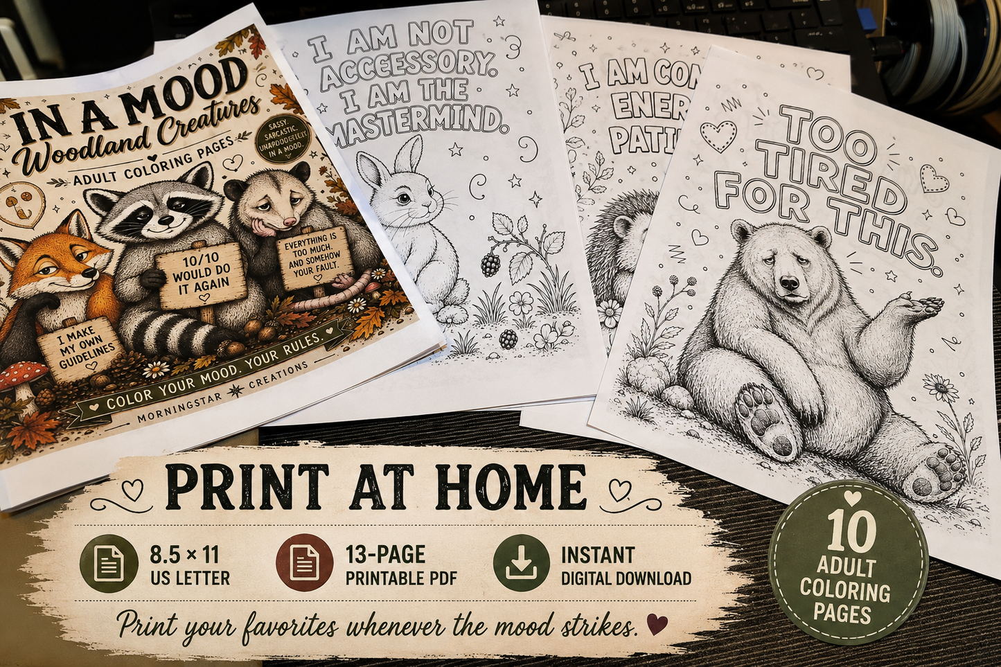 A set of printable adult coloring pages shown in a styled flat-lay on a dark wooden surface. The set includes a cover page with woodland creatures illustrations, three monochrome animal coloring pages (a rabbit, a bear, and a fox), and a promotional banner at the bottom detailing the print-at-home format and 10 adult coloring pages.